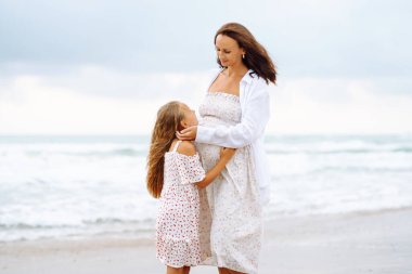 Hamile kadın ve kız gün batımında sahilde gezinirler. Bebek bekleyen genç bir anne, doğada büyük kızıyla vakit geçirir. Aile kavramı, birlikte geçirdiğimiz zaman ve hamilelik..