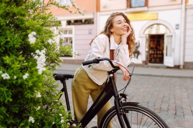 Genç bir turist, şehirde bisikletli güneşli bir günün tadını çıkarıyor. Güzel bir kadın eski kasabada bisiklet sürüyor. Konsept: ulaşım, turizm, yaşam tarzı.