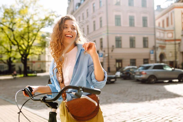 Genç bir turist, şehirde bisikletli güneşli bir günün tadını çıkarıyor. Güzel bir kadın eski kasabada bisiklet sürüyor. Konsept: ulaşım, turizm, yaşam tarzı.