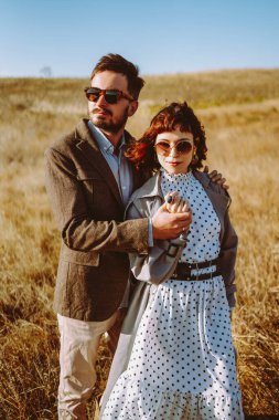 Birbirine aşık genç bir çift güneş ışınlarıyla çimenli bir tarlada geziniyor. Şık bir erkek ve kadın birlikte vakit geçirir, gün batımının tadını çıkarırlar. Aşk, tarz ve moda kavramı.