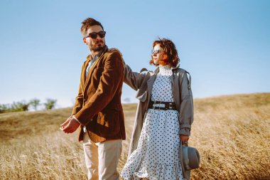 Birbirine aşık genç bir çift güneş ışınlarıyla çimenli bir tarlada geziniyor. Şık bir erkek ve kadın birlikte vakit geçirir, gün batımının tadını çıkarırlar. Aşk, tarz ve moda kavramı.