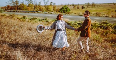 Birbirine aşık genç bir çift güneş ışınlarıyla çimenli bir tarlada geziniyor. Şık bir erkek ve kadın birlikte vakit geçirir, gün batımının tadını çıkarırlar. Aşk, tarz ve moda kavramı.