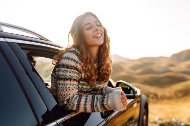 Güzel bir gezgin araba camından dışarı bakar ve dağ manzarasına hayran kalır. Genç kadın kendini özgür hissediyor, gün batımında bir yol gezisinde rüzgarı saçlarıyla yakalıyor. Macera kavramı, özgürlük..