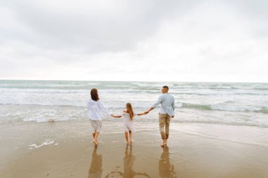 Mutlu bir aile bulutlu bir günde deniz kıyısında gezinir. Genç bir adam, hamile bir kadın ve kızları birlikte vakit geçirip eğleniyorlar. Kavram, aile, rahatlama ve beklenti hakkındadır..