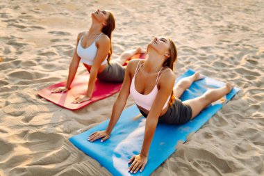 İki arkadaş güneş ışınlarında deniz kıyısındaki minderlerde yoga yapıyor. Atletik kadınlar günbatımı kumsalında egzersiz yapar ve meditasyon yaparlar. Konseptler arasında meditasyon, rahatlama ve dostluk yer alıyor..