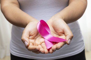 30 yaşında kadın pembe kurdele gösteriyor.
