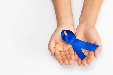 Elinde mavi kurdele olan genç bir kadın..