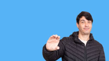 Siyah ceketli adam boş elini gösteriyor..