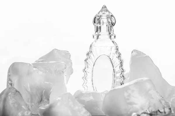 Glass carafe among the blocks of ice on white background. — Stock Photo, Image