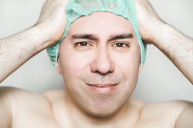 Tıbbi şapkalı erkek hastanın şiddetli bir baş ağrısı var.