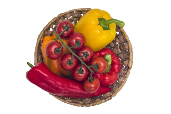 Помидоры и разноцветный перец в корзине на изолированном фоне — стоковое фото