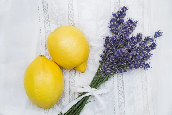 Dantel kumaş üzerine sarı limon ile mor lavanta buket — Stok fotoğraf
