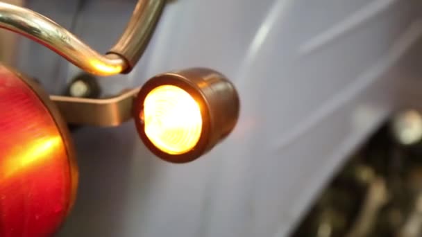 Stary motocykl vintage jest naprawy w garażu z migającymi tylnymi światłami — Wideo stockowe