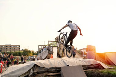 Erkek bisikletçi gün batımında pompa pistinde numara yapıyor..