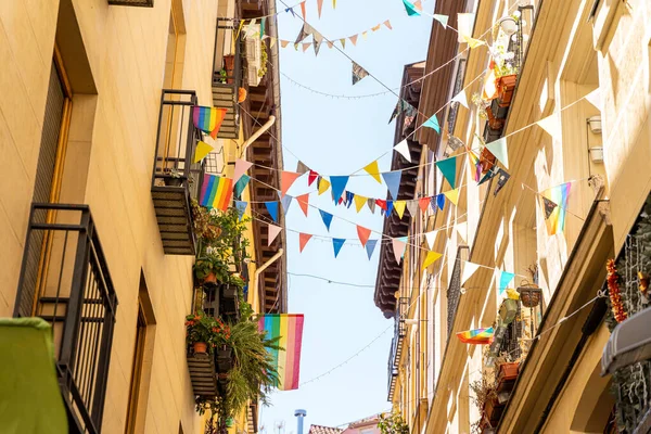 Calle estrecha con antiguas casas amarillas históricas con banderas de orgullo lgbtq en Madrid —  Fotos de Stock