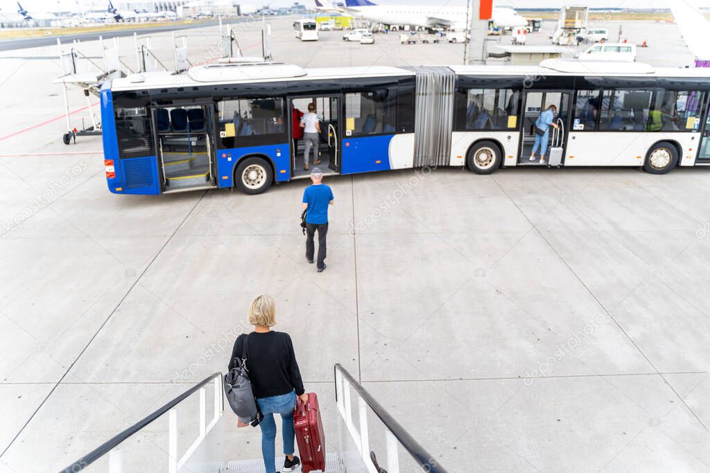 Passengers at the airport with laggage getting off a plane