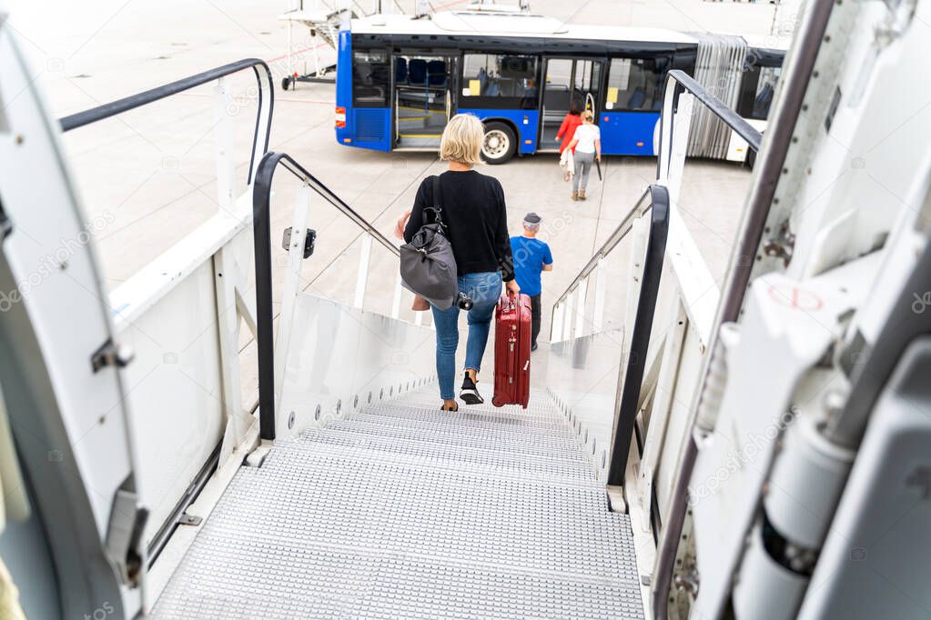 Passengers at the airport with laggage getting off a plane