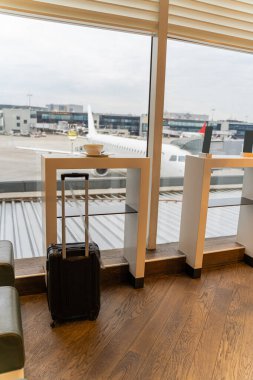 Bir bardak beyaz şarap, bir kase çorba ve havaalanında siyah bir valiz.