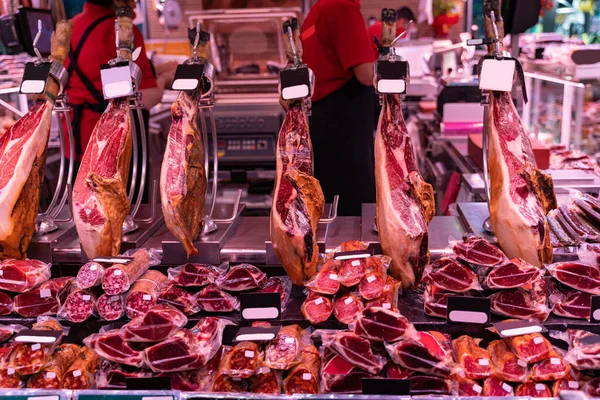 Gran variedad de jamón tradicional español en carnicería en un mercado —  Fotos de Stock