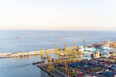 Barcelona 'daki konteynırlar, vinçler ve gemilerle dolu bir deniz kargo limanının hava görüntüsü.