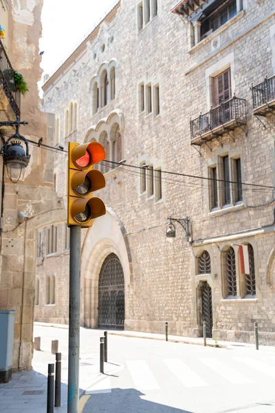 Gult trafikljus som visar rött på gatan med medeltida byggnader i Barcelona — Stockfoto
