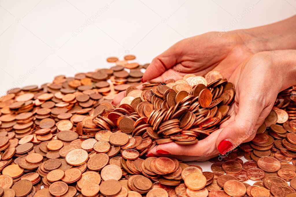 Female hands holding many small euro coins on white background