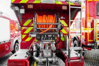 En son turuncu yangın söndürme hortumlarıyla donatılmış itfaiye aracı.