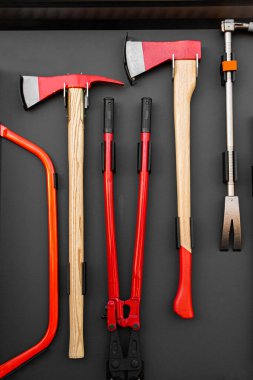 Modern itfaiye aracına bağlı sağlam bir çift balta, pense ve levye.