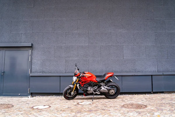 Sportovní závodní výkonný stylový moderní červené motocykl stojí zaparkované na silnici Stock Snímky