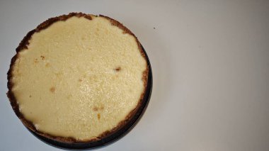 Hafif arka planda altın kabuklu ev yapımı peynirli kek. Ev yapımı tatlı kavramı, pişirme ve tatlı düşkünlüğü