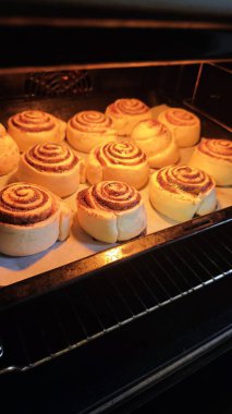 Tarçınlı börekler fırında altın hamur ve şeker kıvrımlarıyla pişiyor. Ev yapımı hamur işi, konforlu pişirme ve tatlı konforlu yemek kavramı