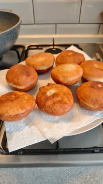 Ev mutfağındaki fırının üzerinde kağıt havluyla soğutulmuş taze kızarmış çörek. Ev yapımı tatlı aperatif konsepti yemek ve pişirme sürecini rahatlatır.