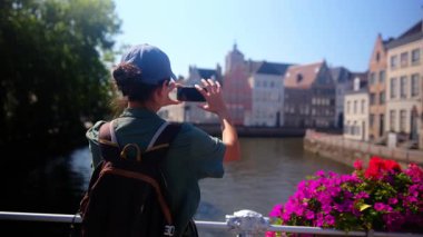 Şehirdeki kanalda fotoğraf çeken bir kadın.