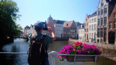 Suyun kenarında akıllı telefon kullanan kadın.