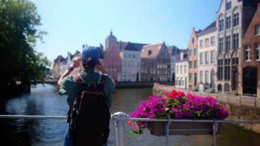 Suyun kenarında akıllı telefon kullanan kadın.