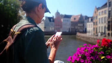 Suyun kenarında akıllı telefon kullanan kadın.