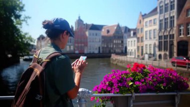 Su kenarında akıllı telefon kullanan bir kadın..