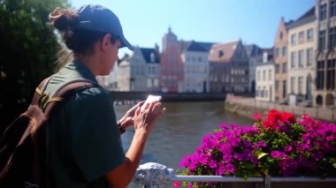 Güzel bir kadın şehrin yakınında akıllı telefon kullanıyor.