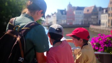 Mutlu kadın ve çocuklar su kenarındaki haritaya bakıyorlar..