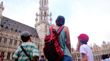 Güzel bir kadın ve küçük çocuklar şehirde yürüyor..