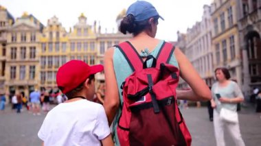 Şehre oğluyla yürüyen kırmızı sırt çantalı güzel bir kadın..