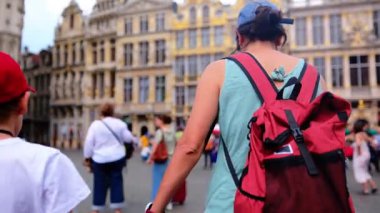 Şehre oğluyla yürüyen kırmızı sırt çantalı güzel bir kadın..