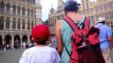 Şehre oğluyla yürüyen kırmızı sırt çantalı güzel bir kadın..