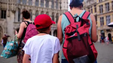 Şehre oğluyla yürüyen kırmızı sırt çantalı güzel bir kadın..