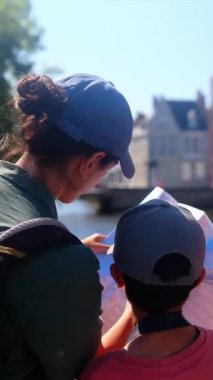 Bir kadın ve küçük oğlu şehirde bir haritayı inceliyor..