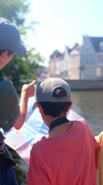 Kadın ve küçük oğulları şehrin su kenarındaki şehir manzaralarını keşfediyorlar..