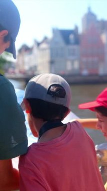 Kadın ve küçük oğulları şehrin su kenarındaki şehir manzaralarını keşfediyorlar..