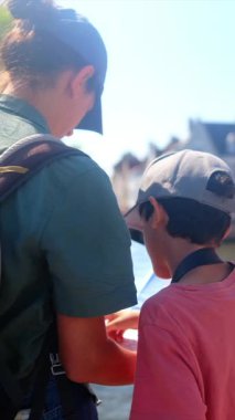 Bir kadın ve küçük oğlu şehirde bir haritayı inceliyor..