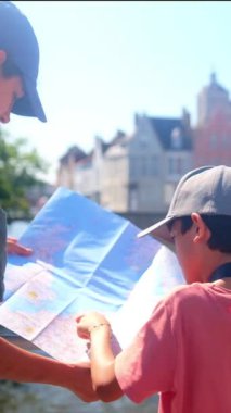 Bir kadın ve küçük oğlu şehirde bir haritayı inceliyor..