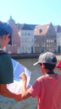 Kadın ve küçük oğulları şehrin su kenarındaki şehir manzaralarını keşfediyorlar..